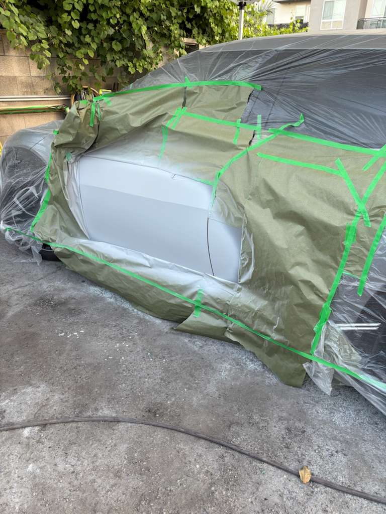 Vehicle carefully masked with paper and tape for precise spot painting